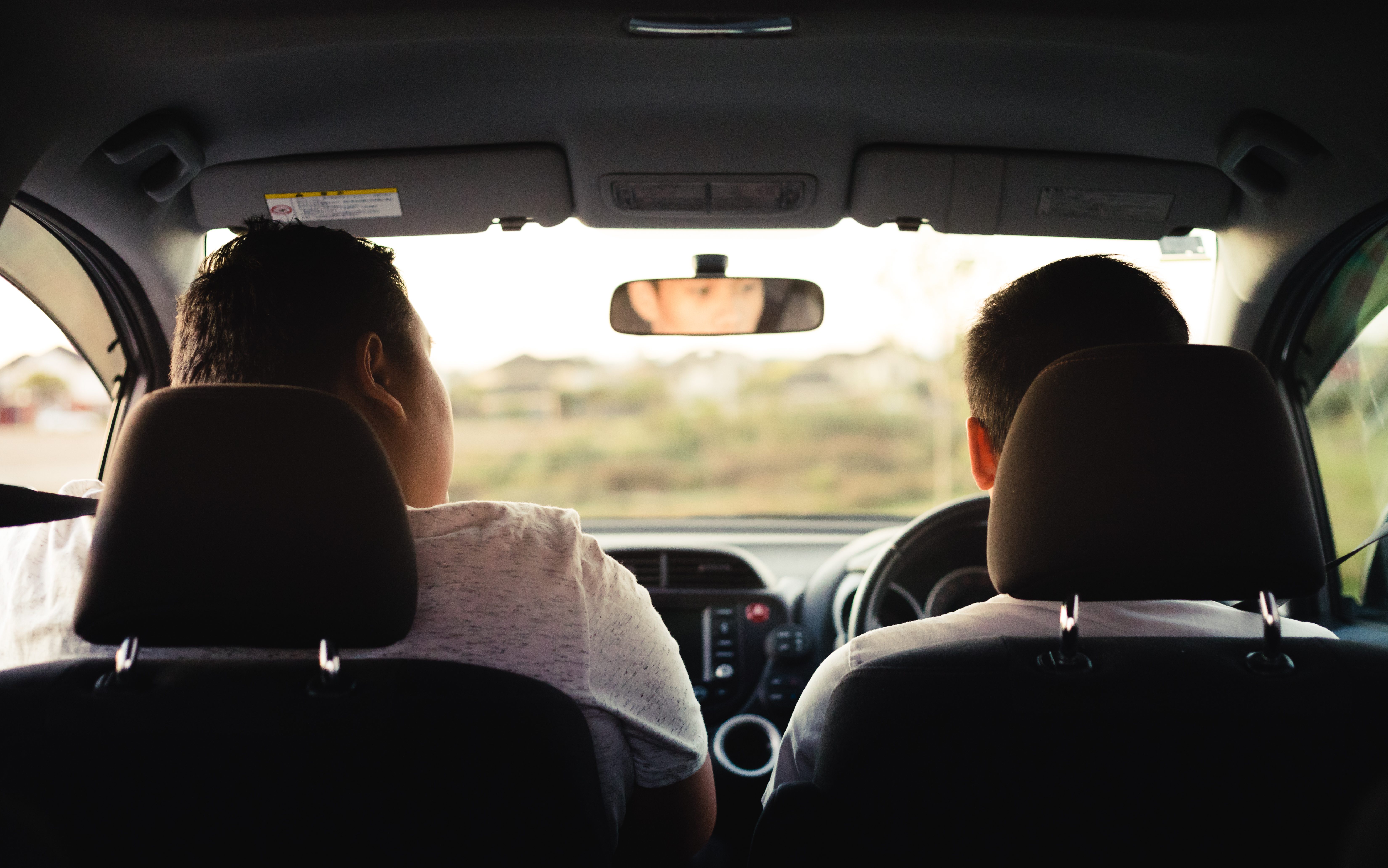 Two people driving in car. One person is training to drive. Driver on right hand side.